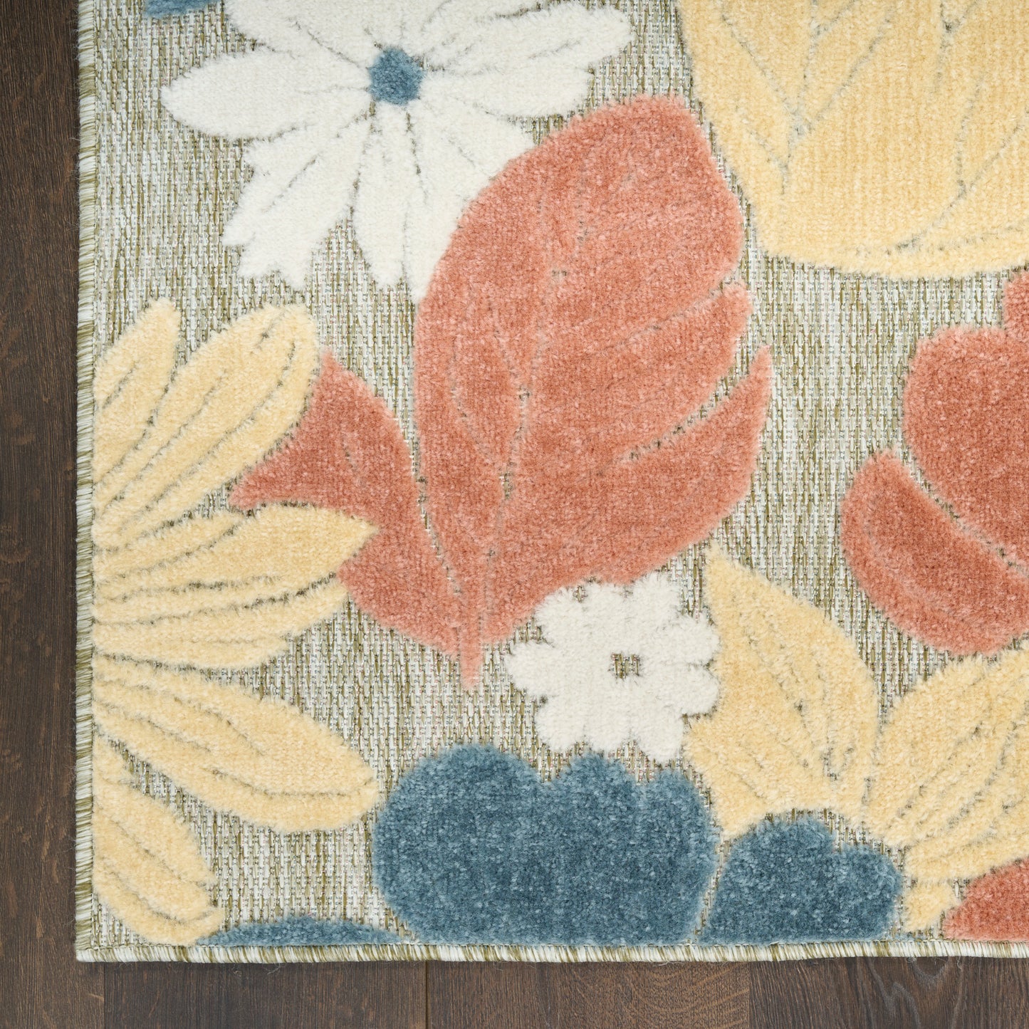 Floral area rug with yellow leaves, peach petals, blue blossoms, white flowers on grey textured background; wood edge.
