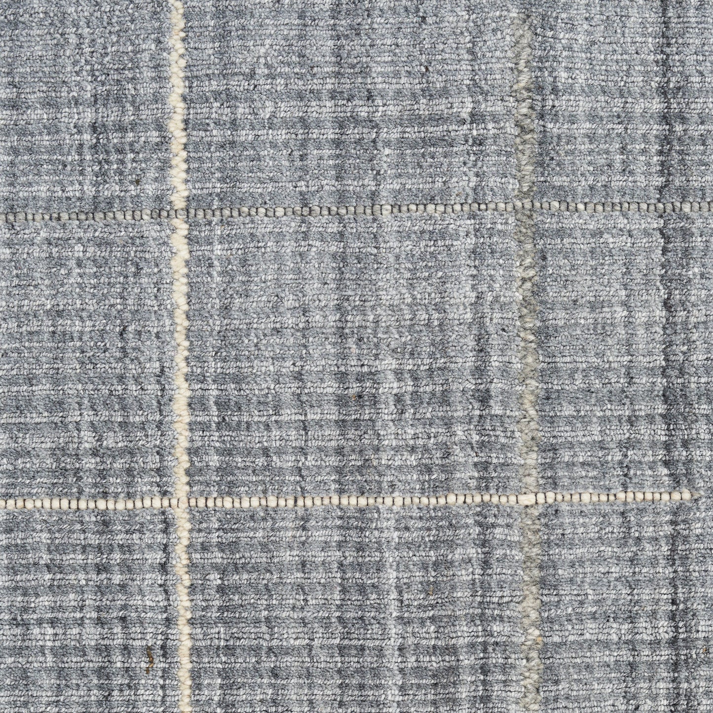 Blue-gray woven rug with beige grid lines in a plaid pattern; textured floor covering.