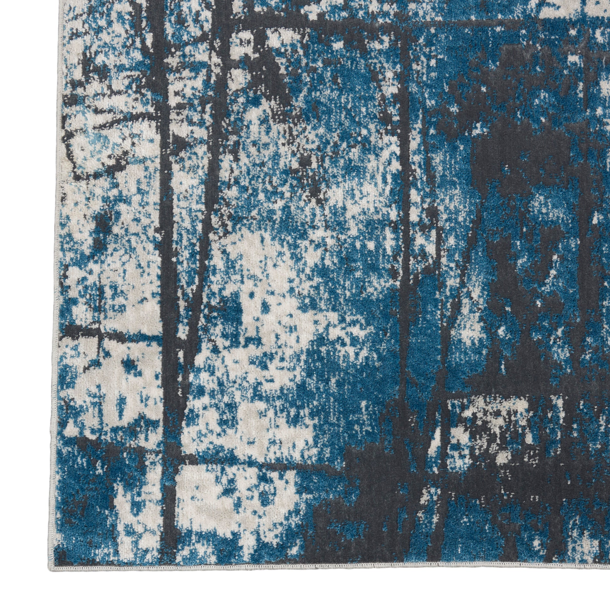 Abstract blue and teal area rug with dark tree-like silhouettes on white speckled background