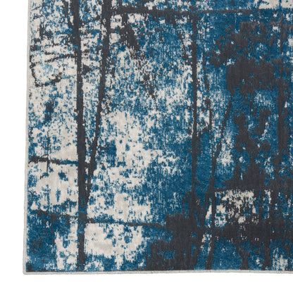 Abstract blue and teal area rug with dark tree-like silhouettes on white speckled background