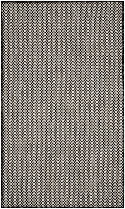 Rectangular beige flatweave rug with black diamond lattice pattern and black border.