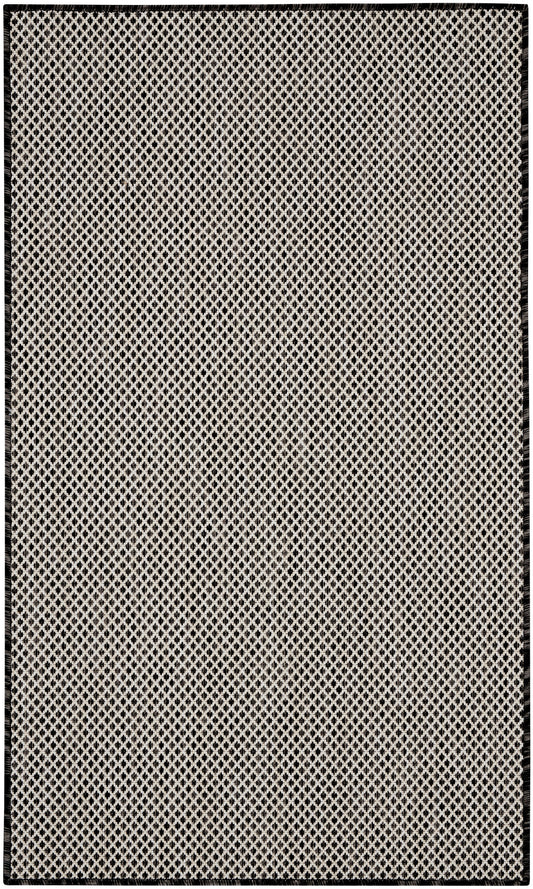 Rectangular beige flatweave rug with black diamond lattice pattern and black border.