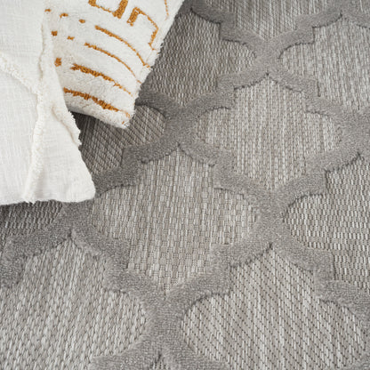 Gray textured rug with interlocking lattice pattern; white towel with orange stripes draped on edge.
