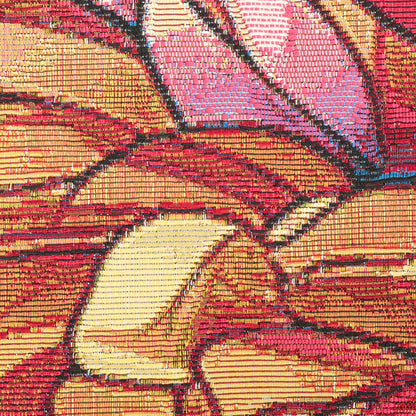 Close-up of a bold, multicolor geometric textile with red, pink, yellow blocks and black outlines.