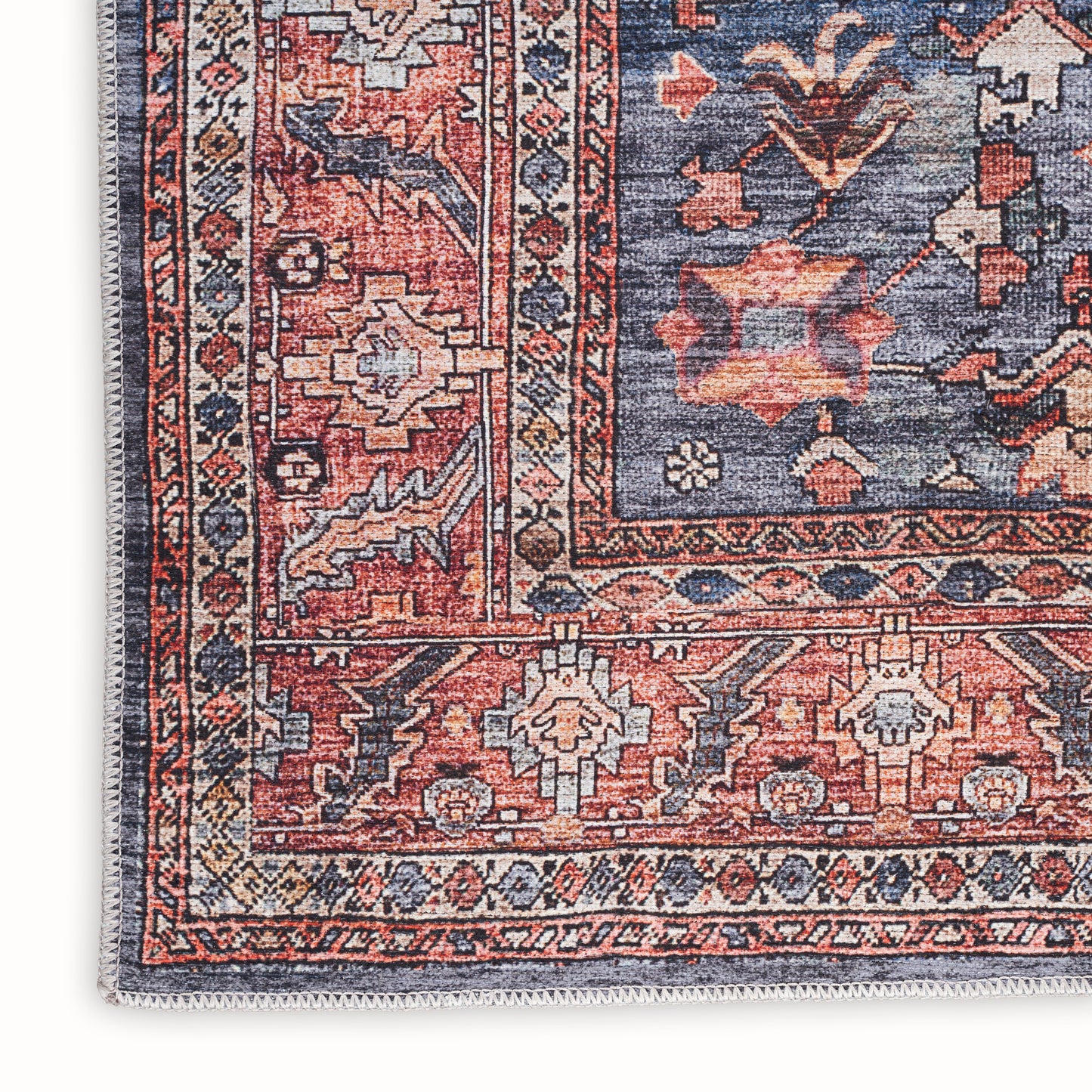 Persian-inspired rug with red, navy blue, ivory geometric borders, floral motifs, fringe edge, rectangular living-room decor.