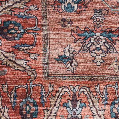 Rust-red oriental rug close-up with blue and cream floral medallions and ornate border.
