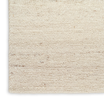 Rectangular cream boucle rug close-up with dense textured pile; soft, cozy for living room floors.