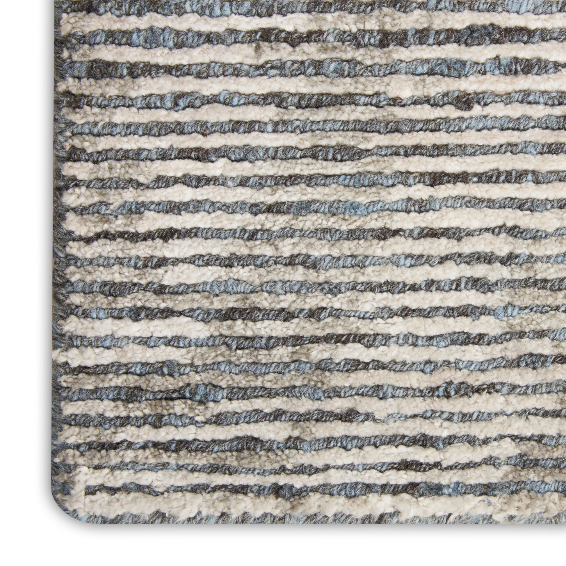 Close-up of a striped textured rug with beige and gray-blue horizontal bands and a rounded corner.