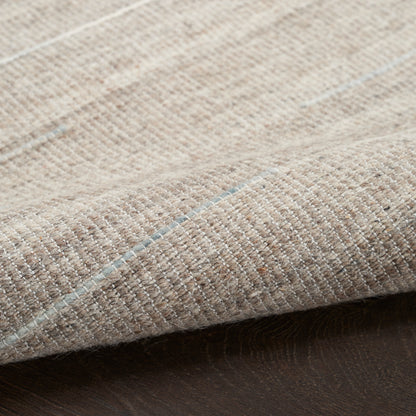 Beige woven rug with pale blue stripes; close-up shows textured fabric and folded edge.