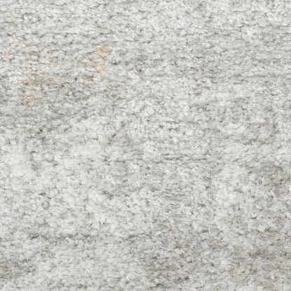 Close-up of a light gray shag rug with fluffy plush fibers and soft texture.