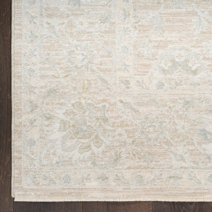Cream-toned area rug with pale blue floral pattern in a vintage oriental style on dark wood floor.