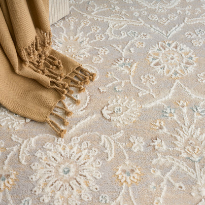 Camel knit scarf with fringed tassels draped on a beige floral rug; cozy winter accessory.