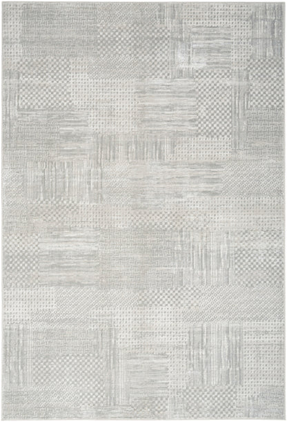 Light gray patchwork rug with subtle check, striped, and dotted patterns; woven texture for modern neutral decor.