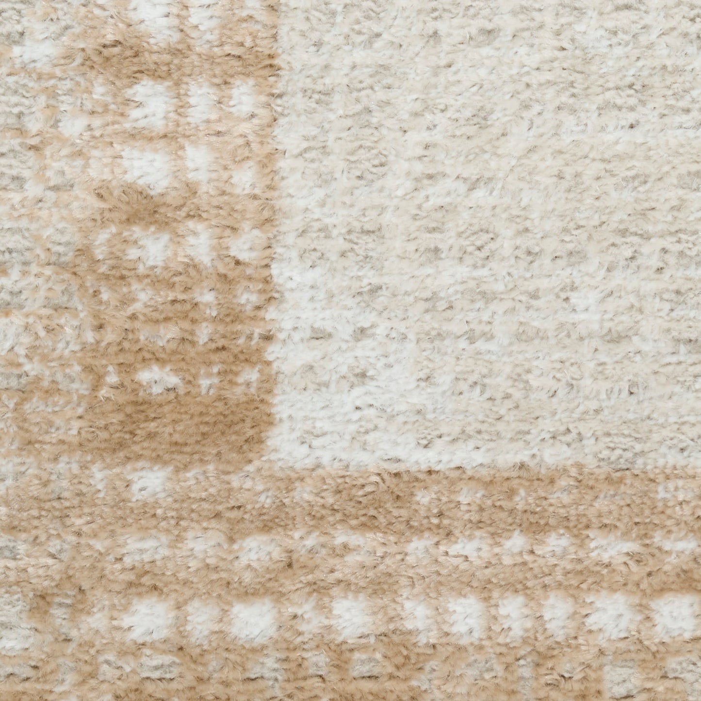 Soft plush patchwork rug in beige and cream tones, textured shag-like pile.