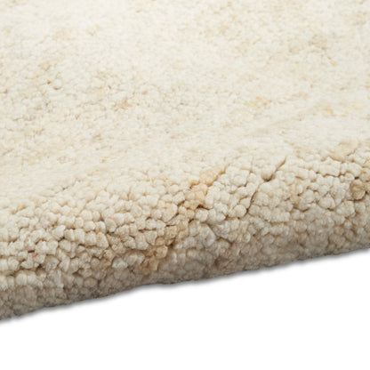 Cream sherpa fleece rug with plush loop texture and rolled edge.