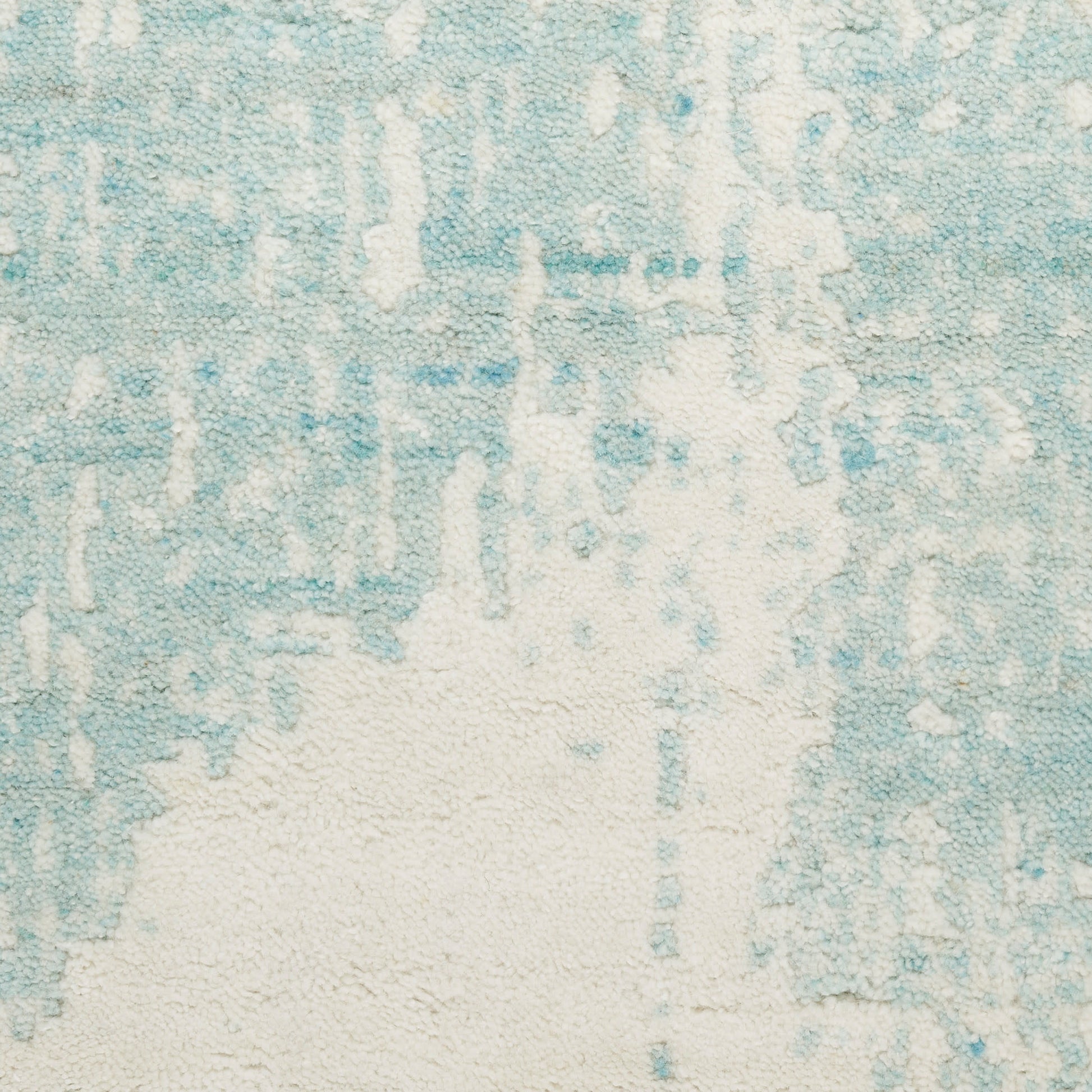 Soft blue and cream abstract-patterned rug with textured pile, coastal contemporary decor.