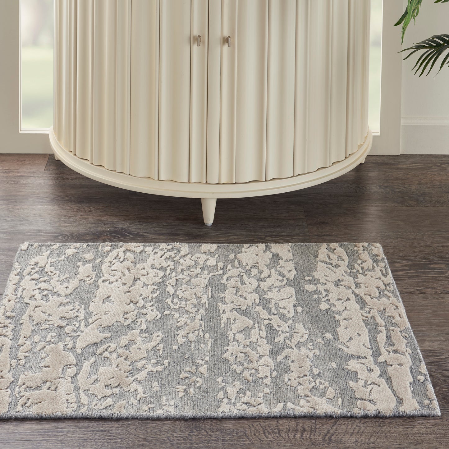Cream modern 2' x 3' rug with a subtle gray pattern on a dark wood floor.
