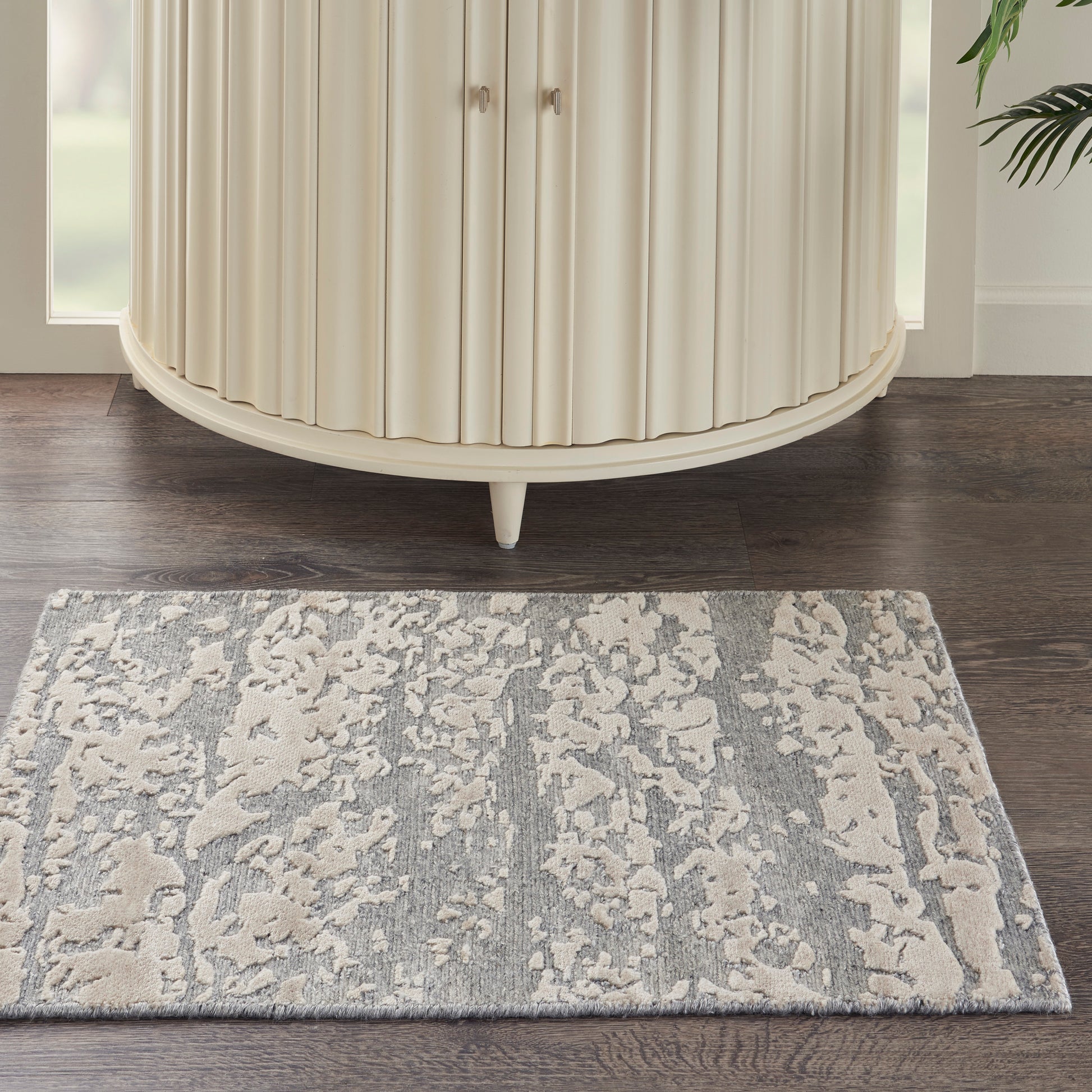 Cream modern 2' x 3' rug with a subtle gray pattern on a dark wood floor.
