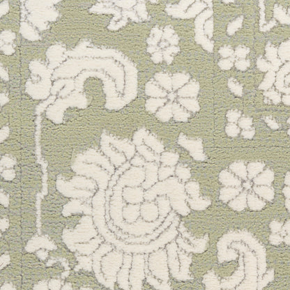 Olive-green rug with white damask floral pattern; decorative, textured textile.