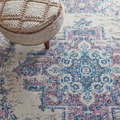 Round beige boucle rug with a blue and pink vintage oriental pattern.