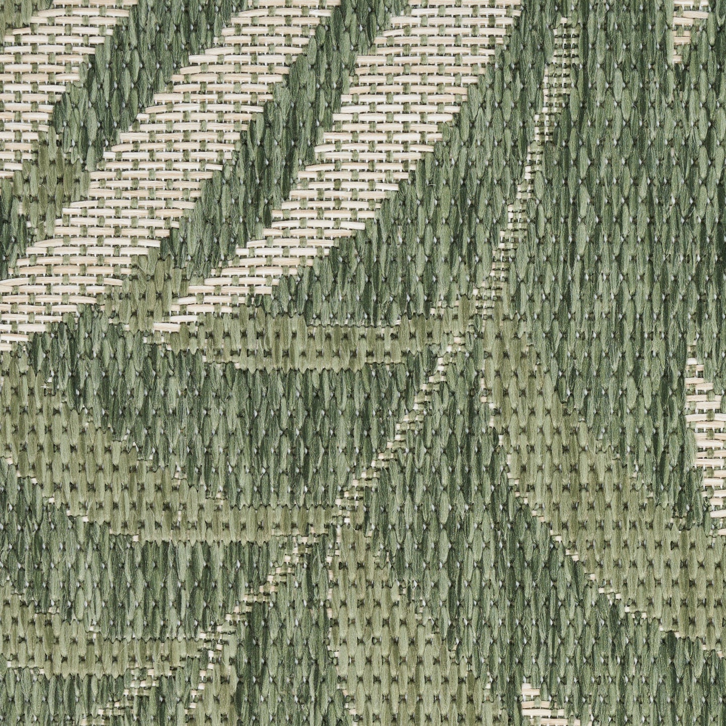 Close-up of olive and sage green woven outdoor rug with a geometric leaf pattern and raised texture.