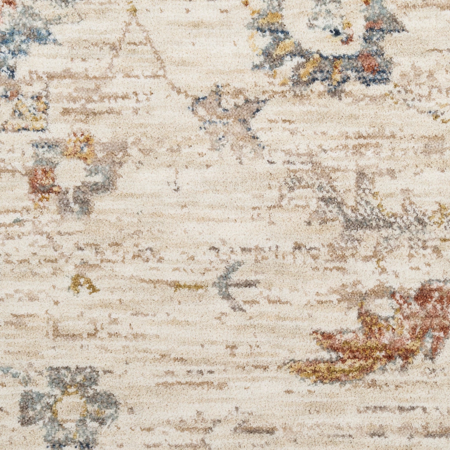 Abstract distressed beige rug with faded floral motifs in blue, rust and sage.
