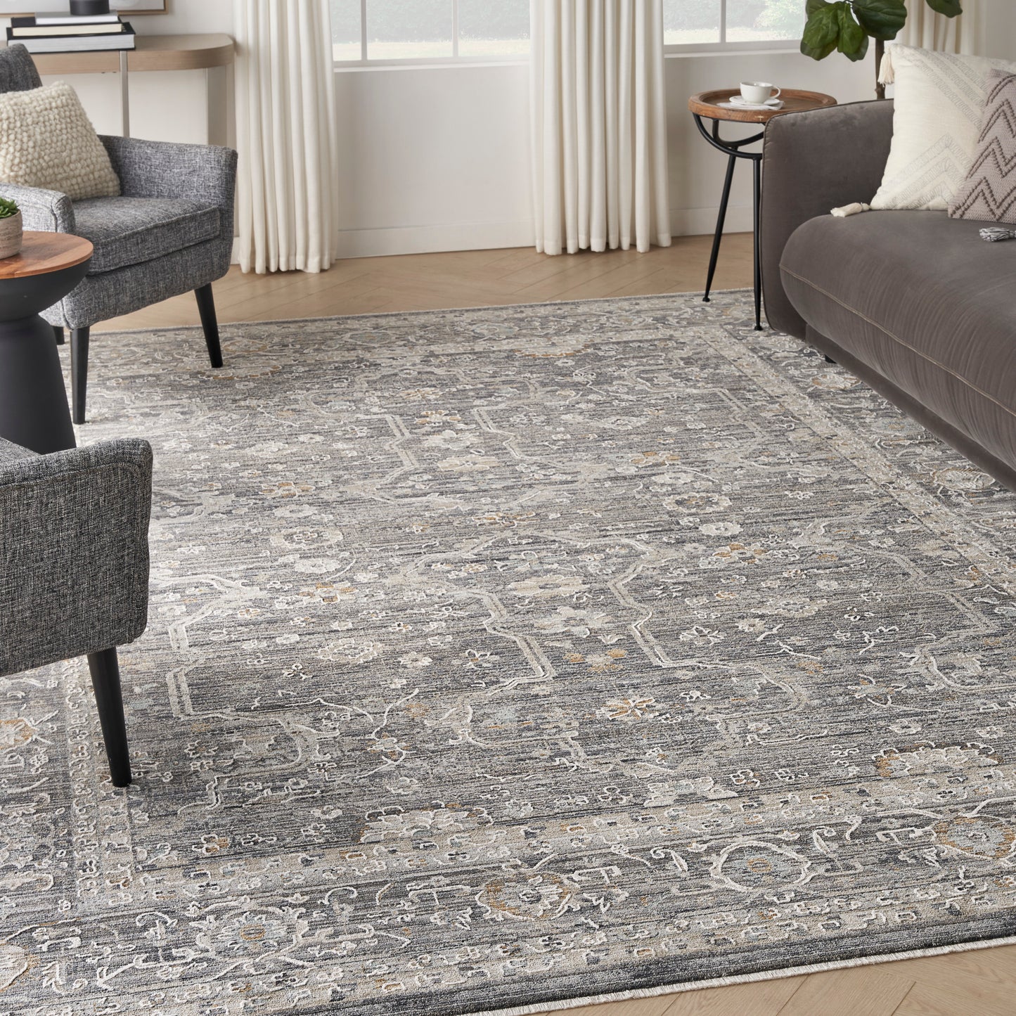 Gray patterned area rug with ivory and pale blue motifs under modern living room seating.