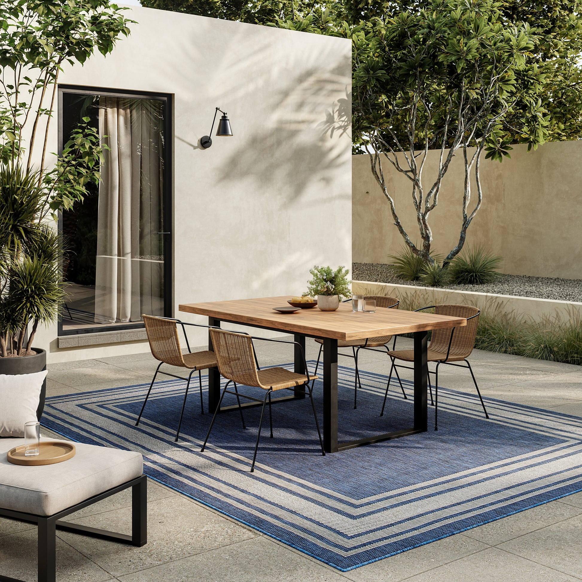 Blue striped outdoor rug, 8' x 10', in a modern courtyard.