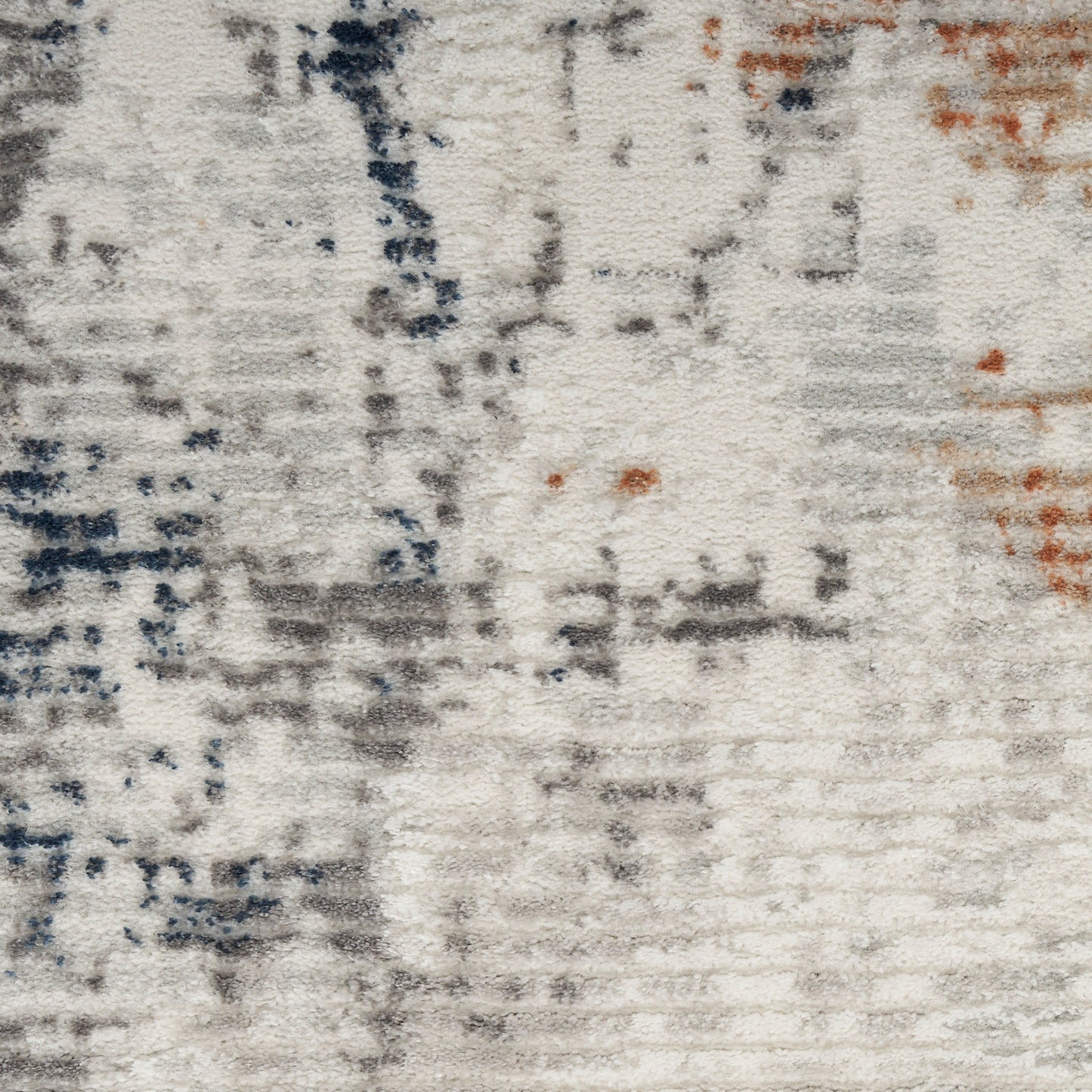 Abstract textured rug with off-white base, gray and navy brushstrokes and small orange accents.