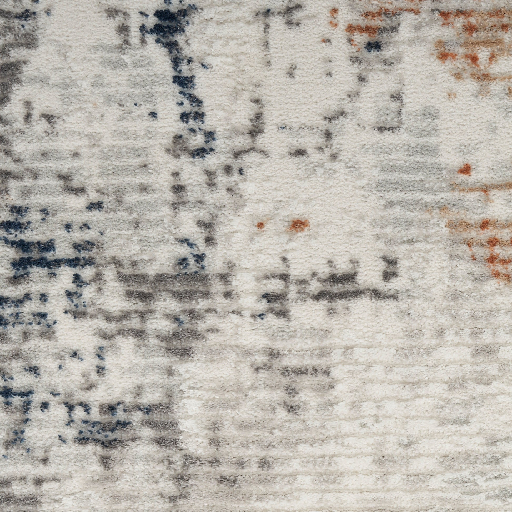 Abstract textured rug with off-white base, gray and navy brushstrokes and small orange accents.