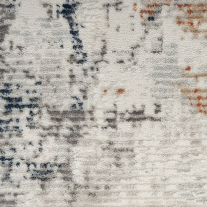 Abstract textured rug with off-white base, gray and navy brushstrokes and small orange accents.