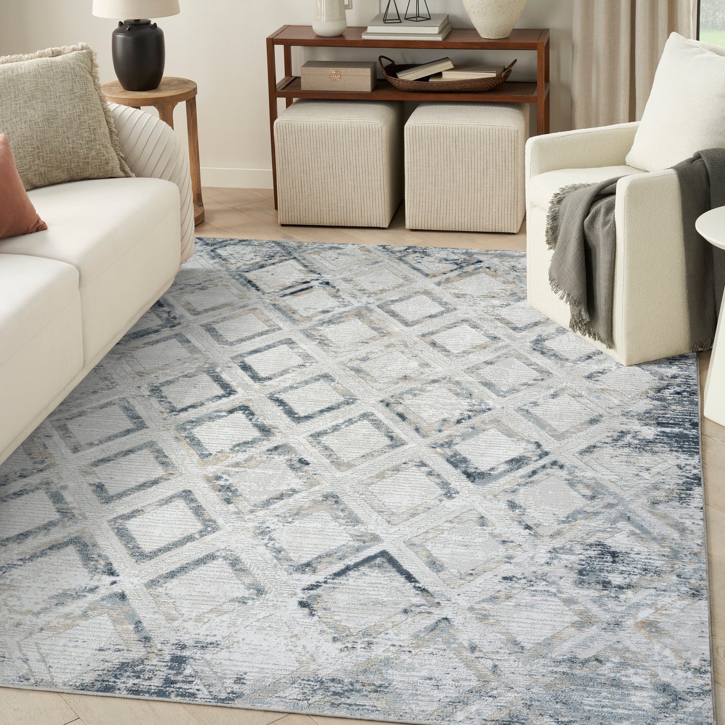 Soft blue-gray geometric area rug with diamond pattern in a modern living room.