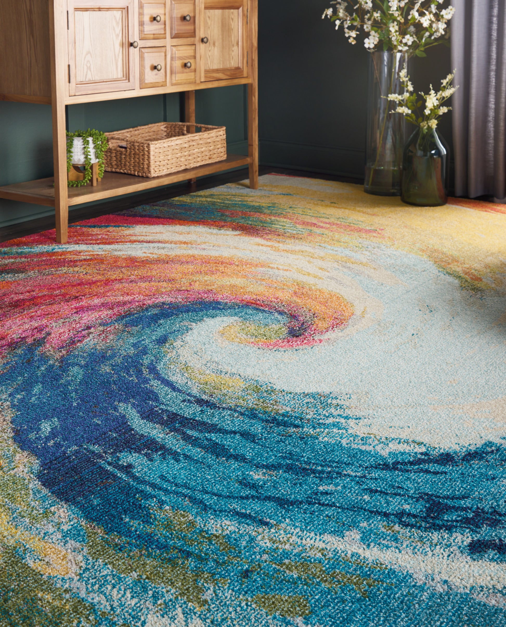 Colorful swirl rug in blues, teals, yellows and pinks; abstract spiral design with a shag texture in a cozy living room.