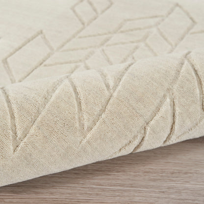 Beige textured rug with geometric diamond pattern, folded corner on light wood floor.