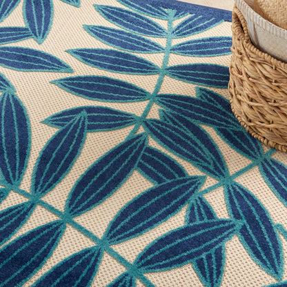 Blue palm-leaf patterned rug on a beige woven background with a partial wicker basket.