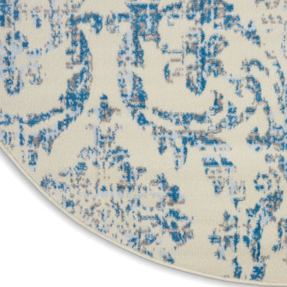 Round cream area rug with an abstract blue distressed pattern; woven texture, modern vintage style.