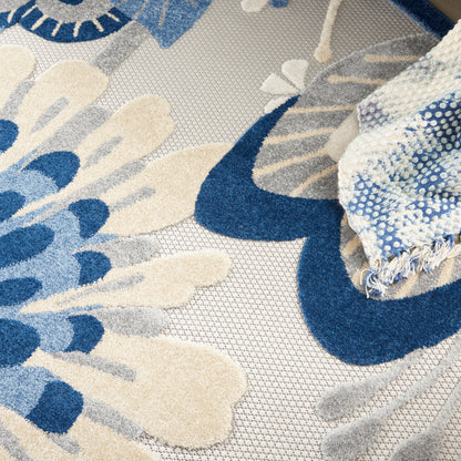 Blue and ivory floral woven rug with beige accents, textured jacquard pattern and fringed edge
