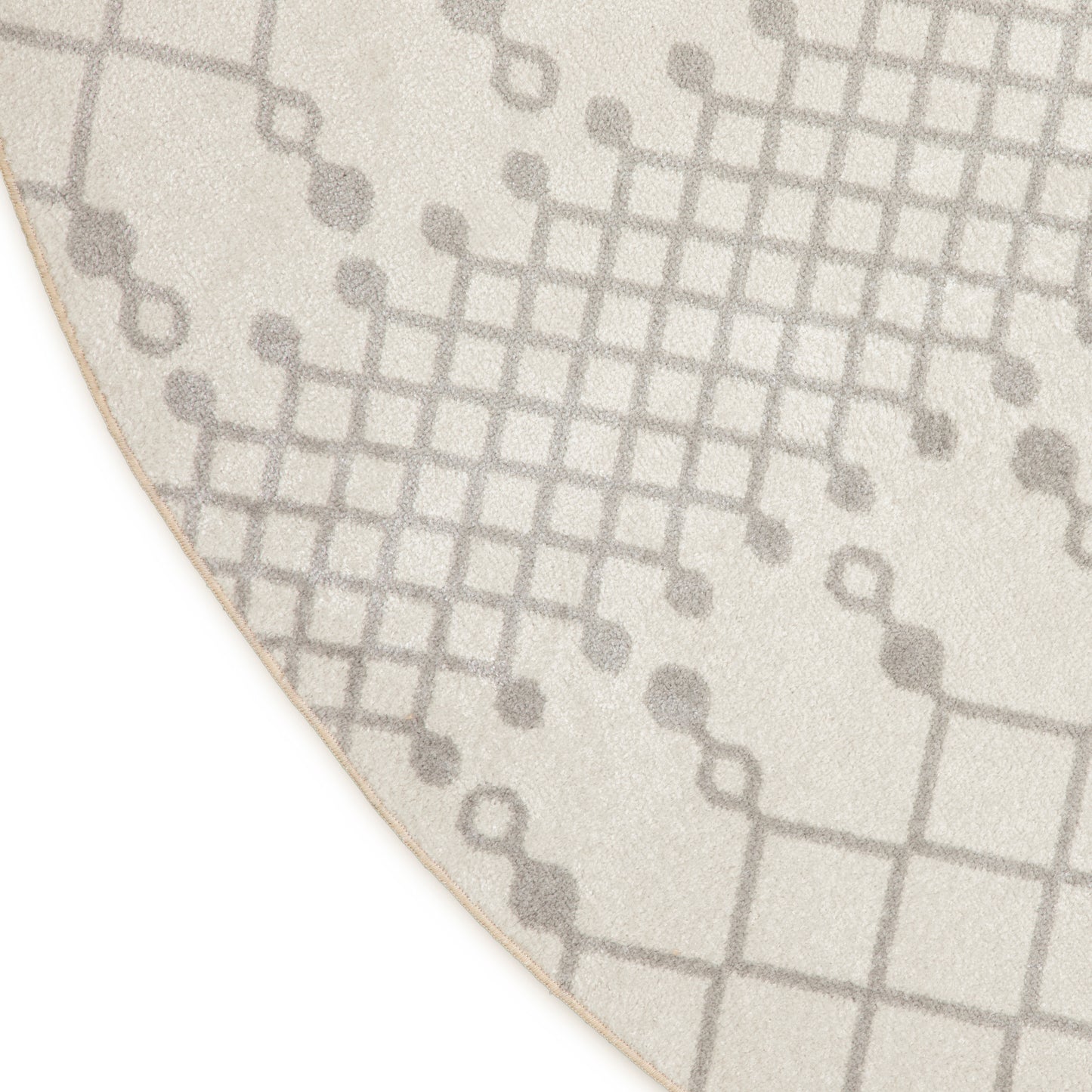 Cream rug with gray grid pattern and circular dot accents; soft textured pile, curved edge.
