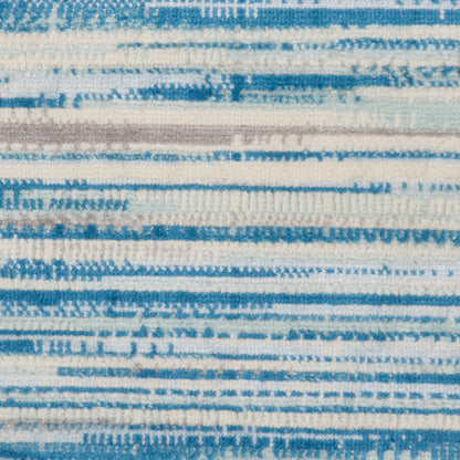 Blue and white striped woven textile with irregular horizontal brush-stroke bands; casual rug or throw.