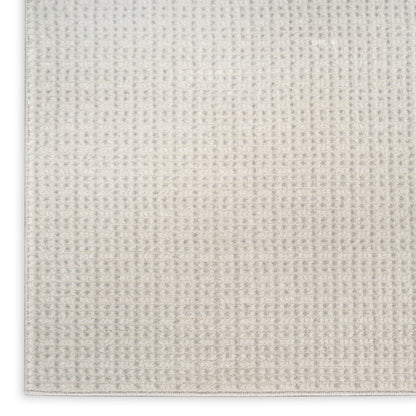 Beige woven textile with a tight grid-like pattern; soft looped rug or upholstery fabric texture.