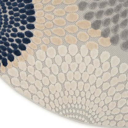 Round area rug with pebble-like dots in navy, beige, taupe and gray; plush looped texture, modern abstract design.