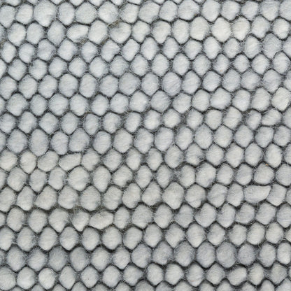 Close-up of light gray boucle fabric with dense rounded loops forming pebble texture.