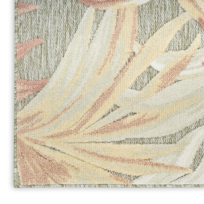 Cream, peach and pale yellow abstract palm-leaf rug on a gray textured background.
