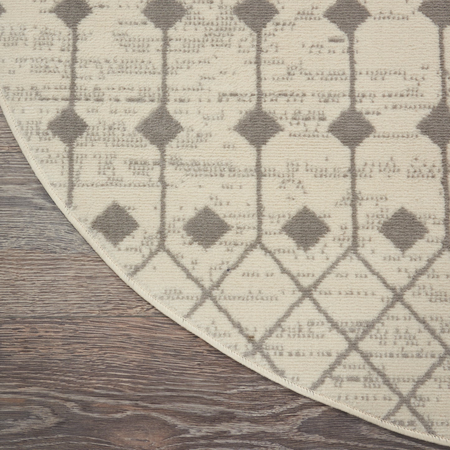 Beige and taupe geometric lattice rug with diamond motif on wood floor; curved edge visible.