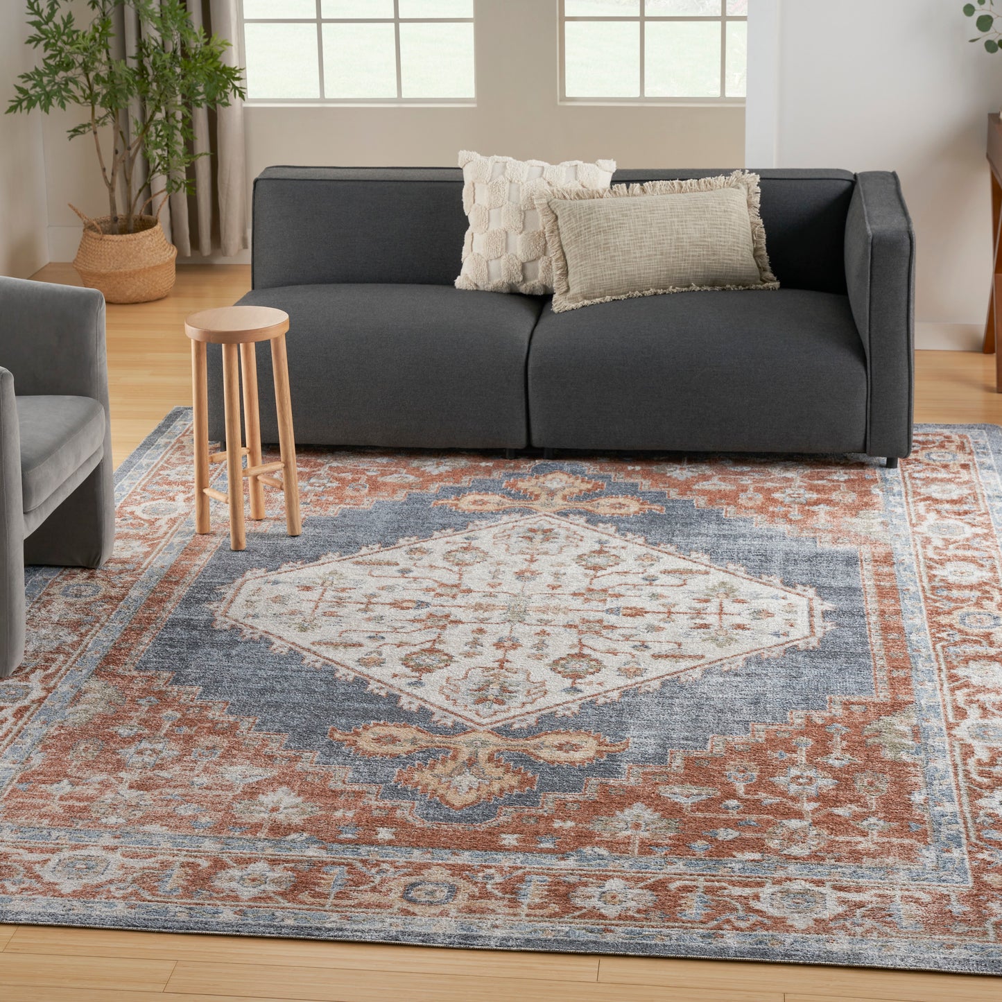 Vintage rust-blue oriental rug, 9' x 12', in a bright living room.
