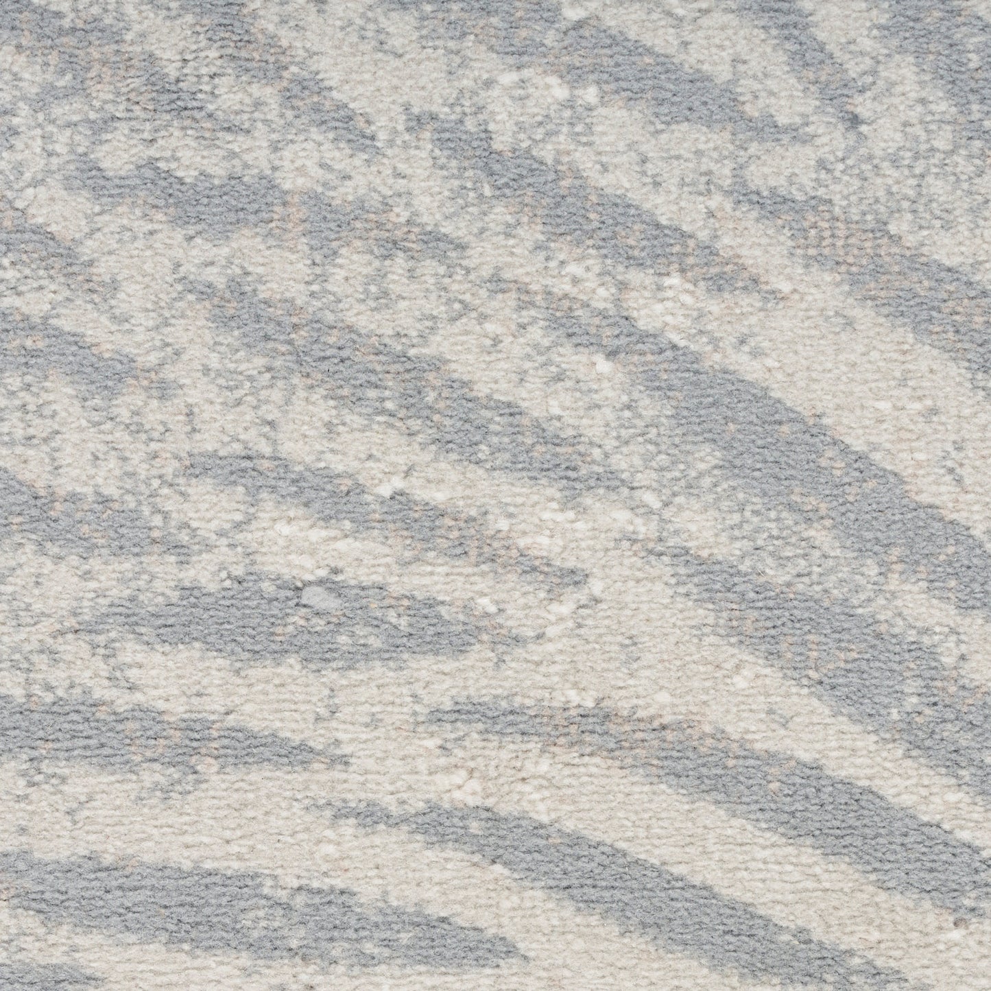 Soft plush rug in gray and ivory with abstract zebra-like waves; cozy modern floor decor.