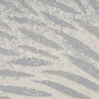 Soft plush rug in gray and ivory with abstract zebra-like waves; cozy modern floor decor.