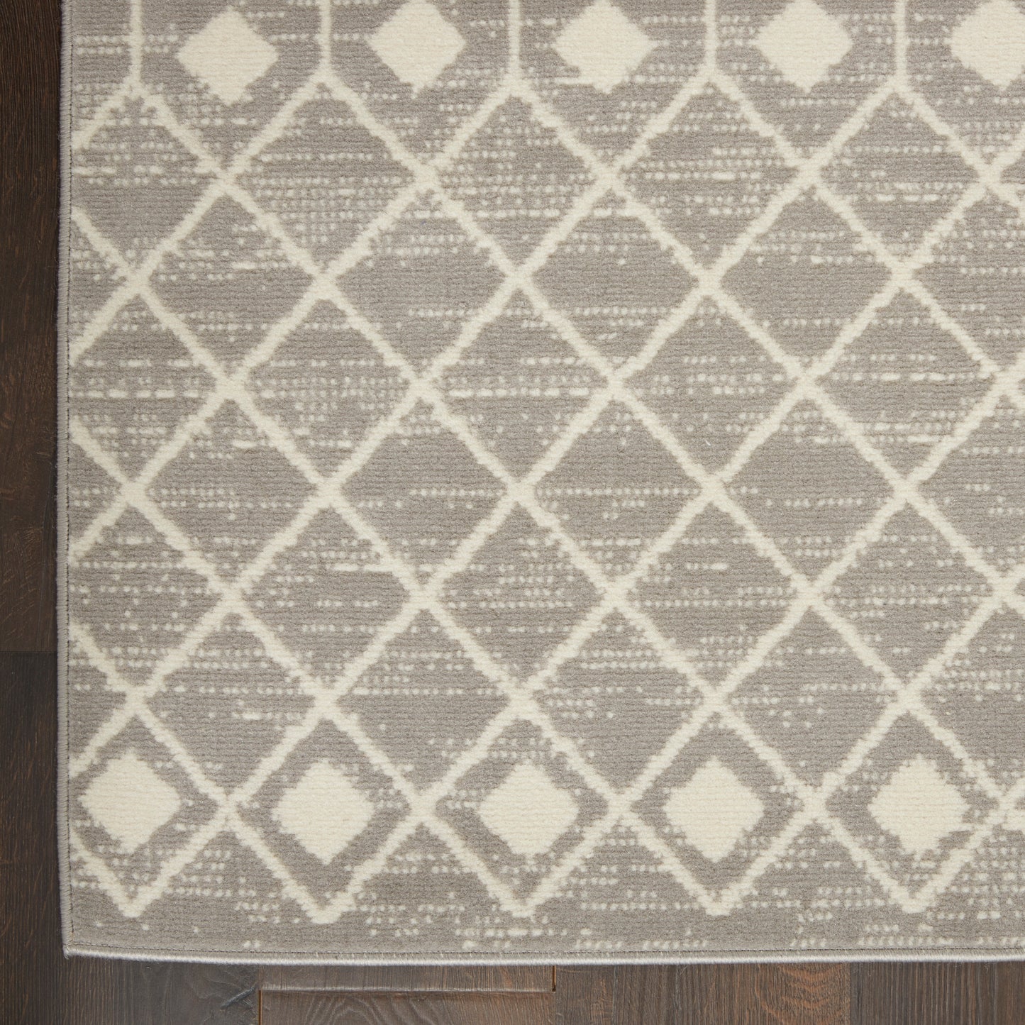 Gray rug with white diamond lattice pattern and woven texture; modern geometric style for living room or hallway.