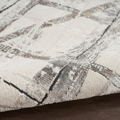 Beige and gray abstract patterned rug with brown accents, low-pile texture on dark wood floor.