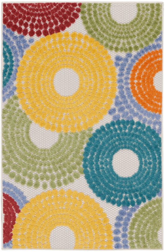 Colorful crochet rug with large yellow, teal, green, orange and red concentric rings on a white backdrop.